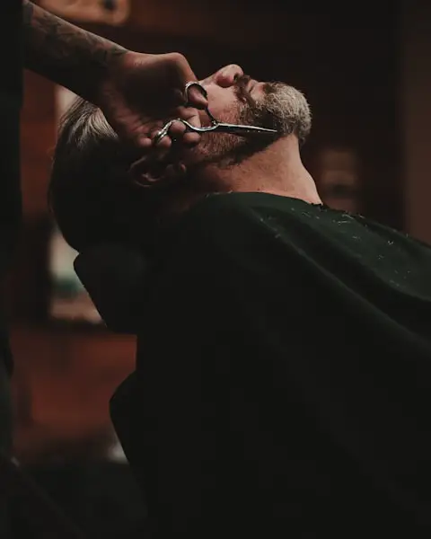 Barber trimming a client's beard