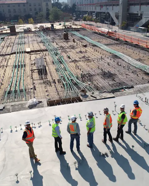 Construction crew in high-visibility vests reviewing a building site