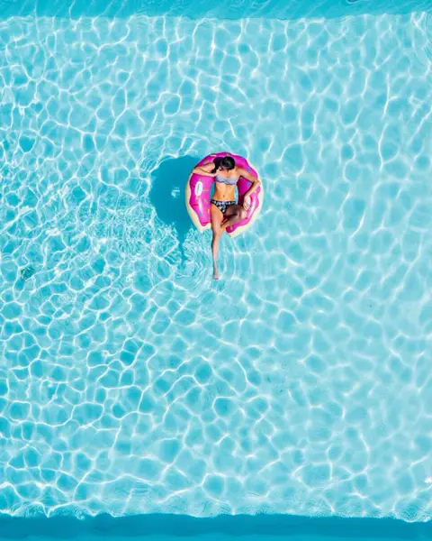 Guest floating on an inflatable ring in turquoise water
